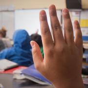 Young student raises hand in classroom