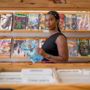 Stephanie Toliver in a comic book store reading an issue of "Ironheart"