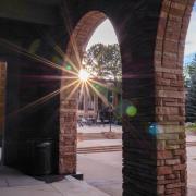 The sun sets, casting rays over the UMC loggia space. 