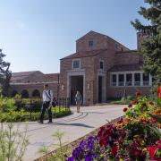 Students walking past UMC, flower beds in full bloom