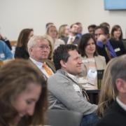 Attendees listen to student presentations at the Leeds Center Showcase. Photo by Glenn Asakawa.