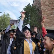 Graduates process to the main commencement ceremony at Folsom Field. Photo by Glenn Asakawa.