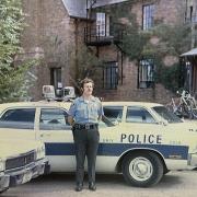 CUPD Officer Joe Armstrong with a late 1960s police car in front of the Armory