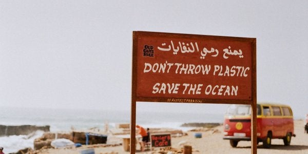A photo of a sign at the beach that reads Don't Throw Plastic, Save the Ocean