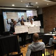 Winners hold up their large prize checks